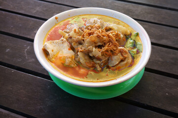Bakso setan (Indonesian). Super spicy meatballs soup with noodles, Chicken feet, tofu and beef fat. Selective focus.     