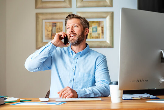 Handsome Businessman Making A Phone Call While Working From Home