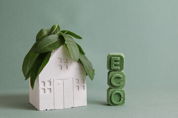 Green building. Eco house concept. House, Green Leaf, Concrete block on green background. Minimal...