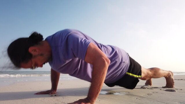 Closeup Of Mature Man Doing Pushups At The Beach.