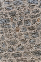 Architecture textures, detailed and rustic of irregular paired masonry granite mix with small holes, traditional spanish granite wall