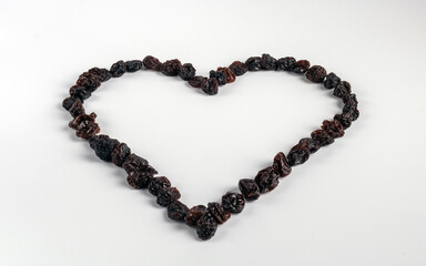 Healthy large raisins, arranged in the shape of a heart.