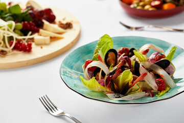 Mussels vongoli in a plate with lettuce, mussels cooked in white wine sauce, seafood served by the chef