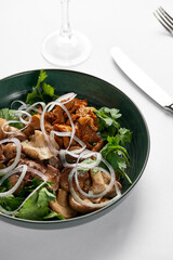Mushrooms with onions and herbs, assorted pickled mushrooms in a plate on a light background, marinated mushrooms with fresh herbs and onions close-up