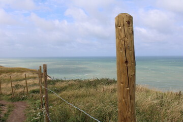 Zoom sur une barrière en bois face à la mer