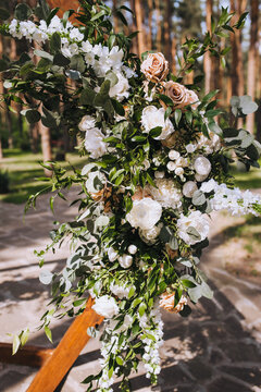 Element of a wedding arch decorated with natural flowers at a ceremony in the forest.