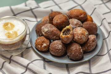 donuts with poppy seeds and cappuccino in a glass