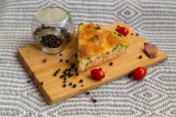 french pie with salmon and broccoli served on a wooden board