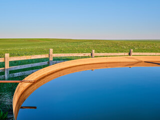 Fototapeta premium cattle water tank in a green prairie - Pawnee National Grassland in northern Colorado, late spring scenery