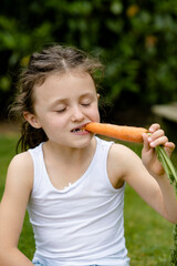 Mädchen beisst in eine Karotte
