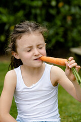 Mädchen beisst in eine Karotte