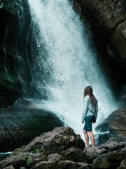 Young woman standing at a waterfall in Michigan's upper peninsula Miners Falls