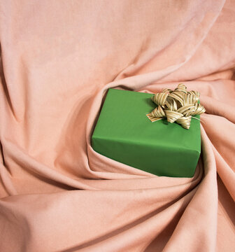 It’s gift-giving time, A gift of a deer wrapper in a golden-pink material that carries it in a whirlpool. Minimalist concept
