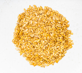 pile of golden flax seeds close up on gray