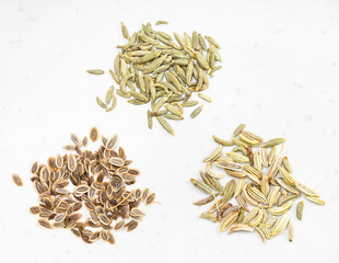 pinches of anise, dill and fennel seeds on gray