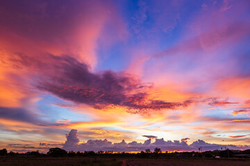 Obraz premium Twilight blue bright and orange yellow dramatic sunset sky in countryside or beach colorful cloudscape texture with white clouds air background.