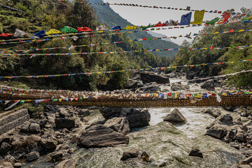 suspension iron bridge with many buddhist holy flags from unique perspective