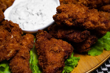 Baked chicken wings with sesame seeds with herbs and sweet sauce in a white box on the table