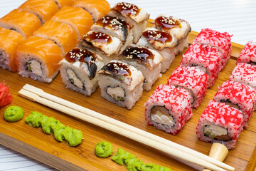 Philadelphia roll sushi with salmon, shrimps, avocado, cream cheese. Sushi menu. Japanese food..Sushi roll isolated on white close up