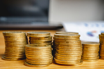 Saving money as a concept. Vintage retro stack of gold coins on the wooden background to represent It's time to do investing for retirement planning.