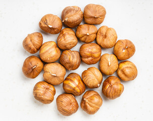 top view of pile of shelled hazelnuts on gray