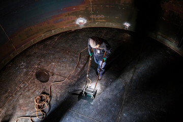 Male worker inspection scan tank of rust thickness bottom plate