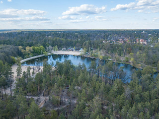 Lake in the coniferous forest in spring. Aerial drone view.