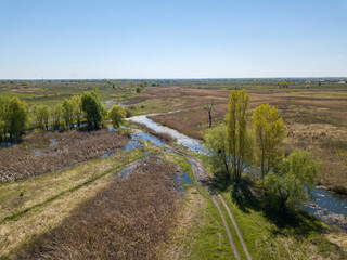River spill on a green meadow. Aerial drone view.