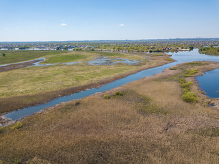 River spill on a green meadow. Aerial drone view.