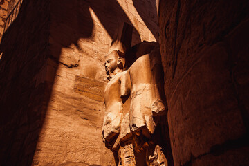 Row of carved statues with blue sky at Karnak Temple, Luxor, Egypt 