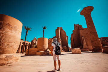 A male tourist stands at the entrance to Karnak Temple, Luxor, Egypt.