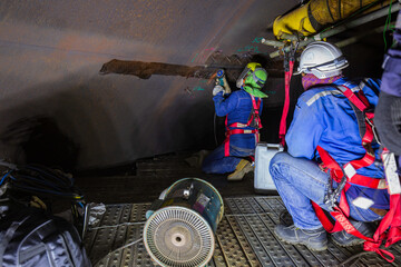 Male  worker inspection  tank of rust thickness in to confined