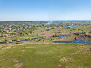 River spill on a green meadow. Aerial drone view.