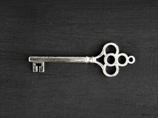 Silver modern key on black wooden background