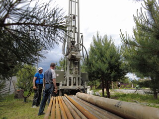 Europe, Kiev region, Ukraine - June 2021: An engineer is drilling a water well. Drilling rig worker...