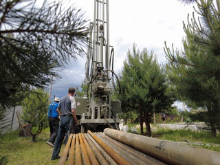 Europe, Kiev region, Ukraine - June 2021: An engineer is drilling a water well. Drilling rig worker...