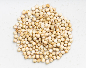 pile of raw unpolished Sorghum grains on gray