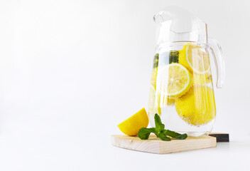 a pitcher of lemons and mint on a wooden board