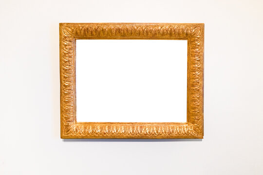 old carved wide wood picture frame on white wall