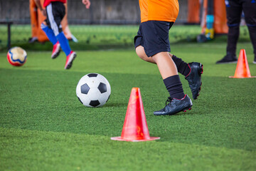 Children playing control soccer ball tactics on grass field with for training
