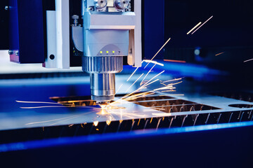 Industrial background CNC laser machine cutting sheet metal with light spark. Concept modern steel...
