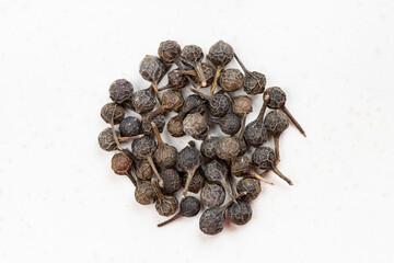 pile of tailed pepper (cubeb) close up on gray