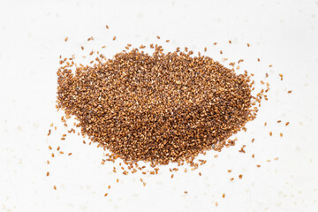pile of whole-grain teff seeds close up on gray