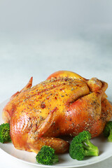 Fried chicken with a golden crust with broccoli and potatoes on a white plate on a white background. Fried poultry with spices and vegetables. Background image for advertising, copy space