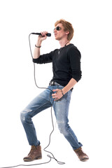 Side view of energetic passionate rocker singer singing loud on microphone. Full body length isolated on white background.