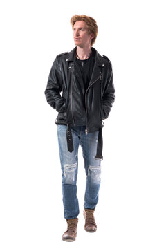 Confident handsome young man in leather jacket walking and looking away. Full body length isolated on white background.