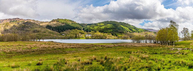 A panorama view across Loch Achray in the Scottish Highlands on a summers day