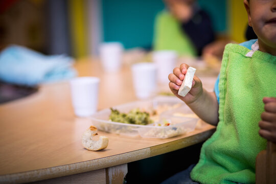 enfant qui mange du fromage lors d'une repas dans une cr&egrave;che