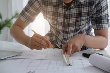 Architect or engineer working in office with blueprints,engineer inspection in workplace for architectural plan,sketching a construction project ,selective focus,Business construction concept.