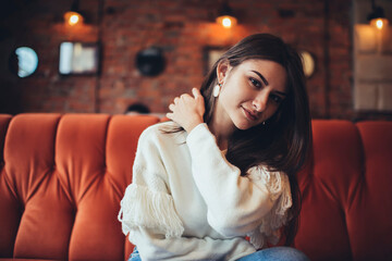 Fototapeta premium Young woman touching hair in cafeteria